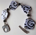 Bracelet en plastique dingue blanc volutes noires et argentées